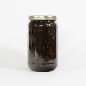 A glass jar filled with dark pickled vegetables or preserves.